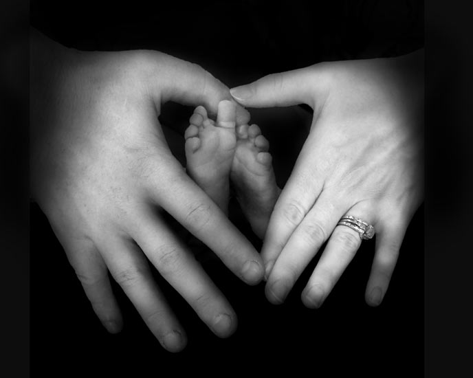 heart shape with baby's feet and parent's hands